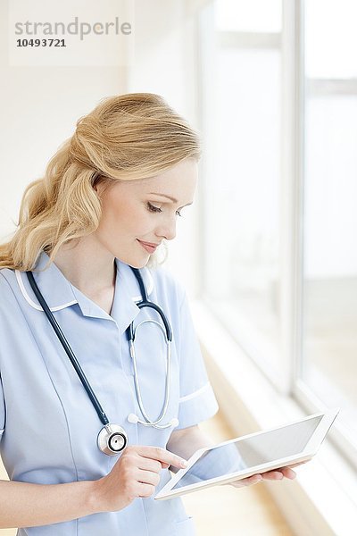 MODELL FREIGEGEBEN. Krankenschwester  die einen Tablet-Computer benutzt Krankenschwester  die einen Tablet-Computer benutzt