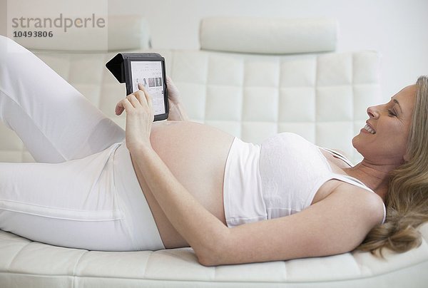 MODELL FREIGEGEBEN. Schwangere Frau mit Tablet-Computer Schwangere Frau mit Tablet-Computer