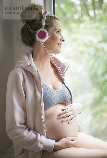 MODELL FREIGEGEBEN. Schwangere Frau beim Musikhören Schwangere Frau beim Musikhören
