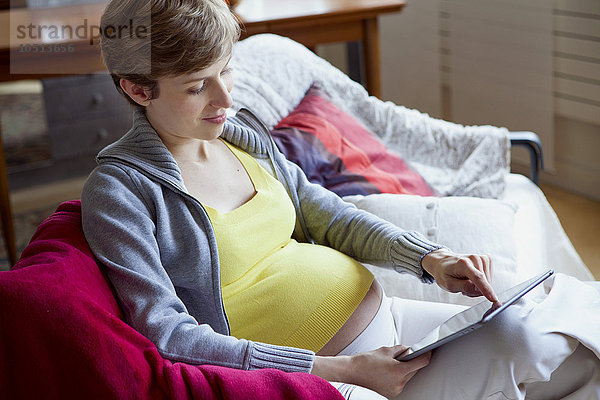 Schwangere Frau mit Tablet-Computer.