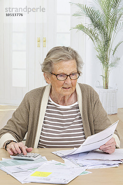 Ältere Frau erledigt Papierkram.