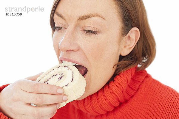 MODELL FREIGEGEBEN. Frau beißt in ein Stück Kuchen  Frau isst Kuchen