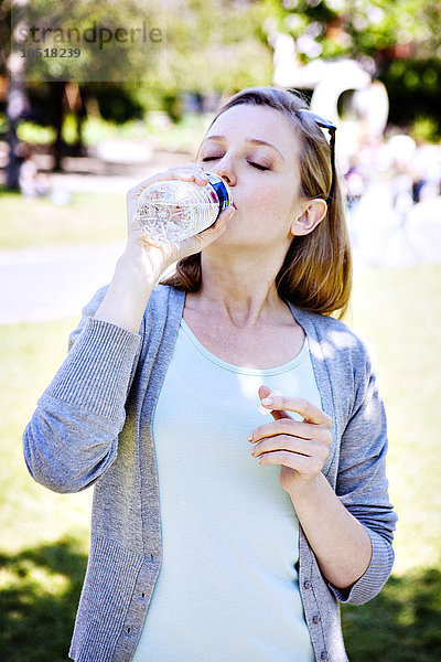 Frau trinkt Wasser.