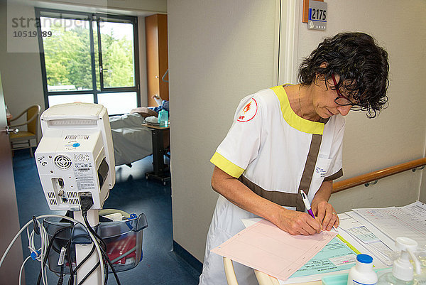 Reportage in der Gruppe des Krankenhauses St. Grgoire in Rennes  Frankreich. Station für Kurzzeitpflege. Nach der Besichtigung der Zimmer notiert die Krankenschwester die Vitaldaten der Patienten.
