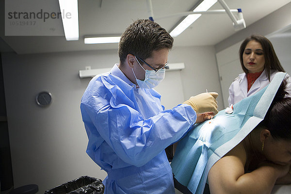 Reportage in einer dermatologischen Praxis in Genf  Schweiz. Der Dermatologe entfernt eine Zyste.