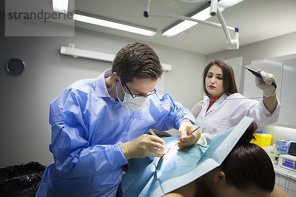 Reportage in einer dermatologischen Praxis in Genf  Schweiz. Der Dermatologe entfernt eine Zyste  unterstützt von seiner Assistentin.