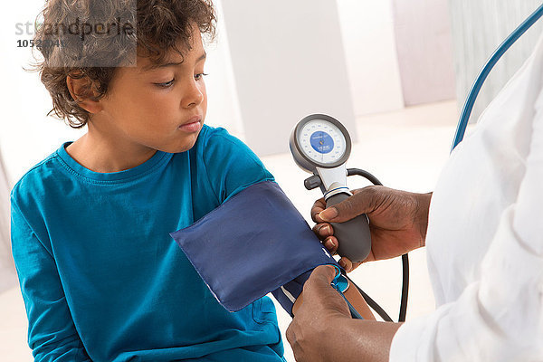 Ein Arzt misst den Blutdruck eines Kindes.