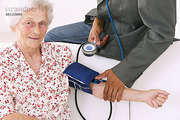 Ein Arzt misst den Blutdruck eines Patienten.