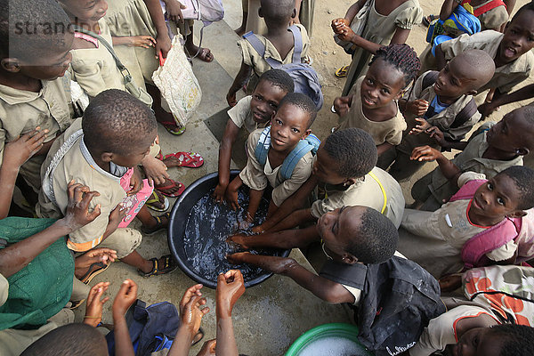 Afrikanische Grundschule (Togo). Schülerinnen und Schüler waschen sich vor dem Mittagessen die Hände.