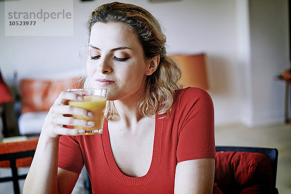 Frau trinkt Orangensaft.