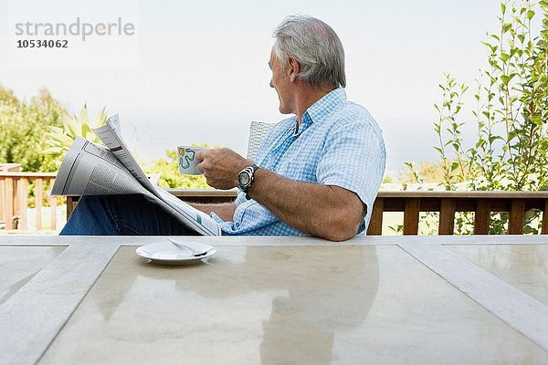 Älterer erwachsener Mann beim Lesen der Zeitung