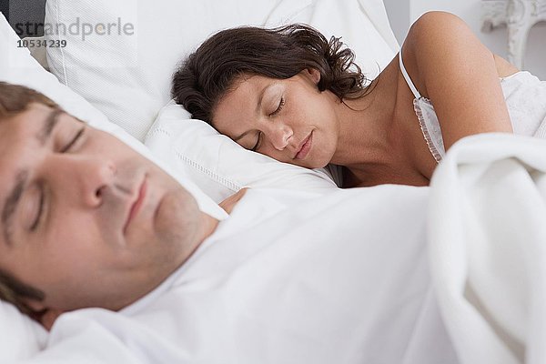 Paar schläft im Bett