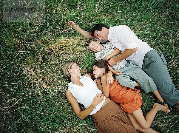 Familie auf dem Rasen liegend