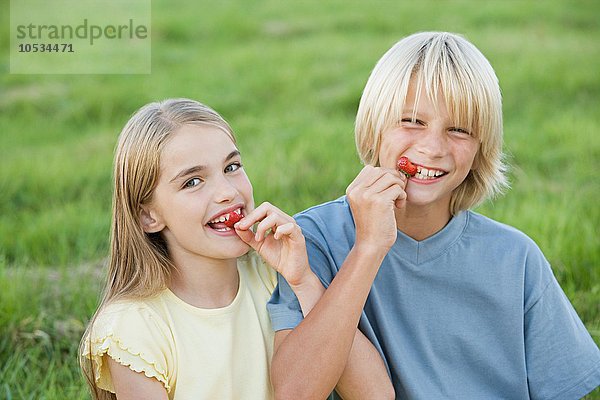 Junge und Mädchen essen Erdbeeren