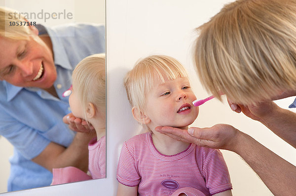 Vater putzt die Zähne der Kleinkind-Tochter
