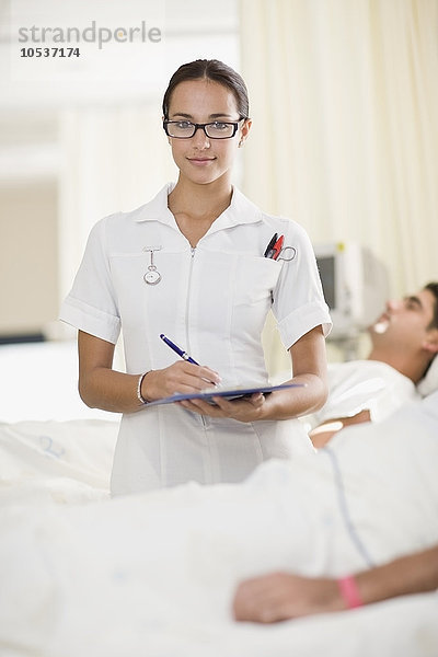 Krankenschwester mit Klemmbrett im Krankenzimmer