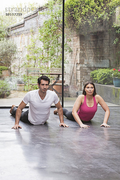 Paar  das zu Hause gemeinsam Yoga praktiziert