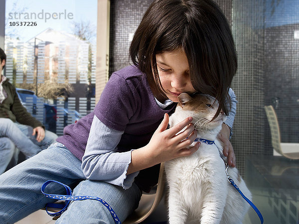 Mädchen mit ihrer Katze im Wartezimmer des Tierarztes
