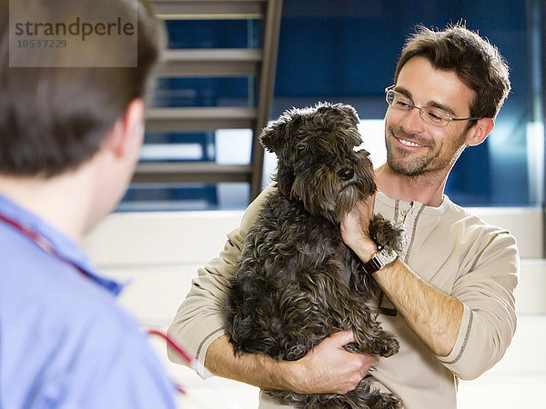 Mann mit Hund beim Tierarzt