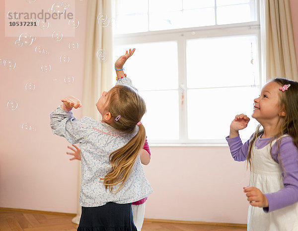 Mädchen spielen zusammen mit Blasen