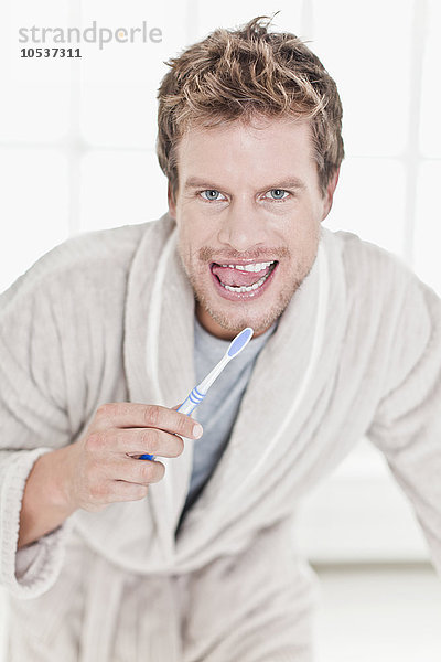 Mann beim Zähneputzen im Bad