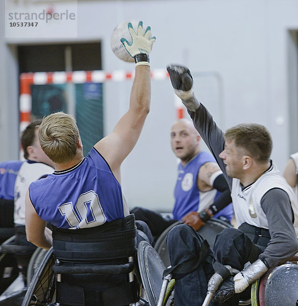Männer im Rollstuhl spielen Pararugby