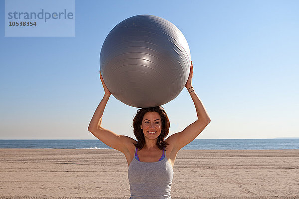 Frau am Strand mit Übungsball