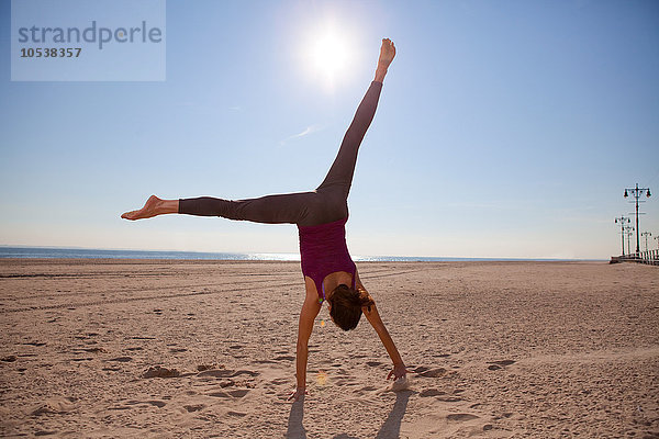 Frau beim Cartwheeling am Strand