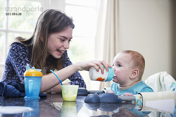 Mädchen füttern Baby-Bruder am Tisch