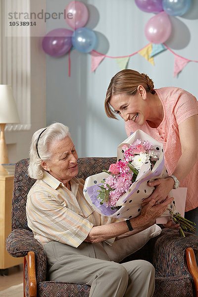 Tochter schenkt Senior-Mutter Blumenstrauß