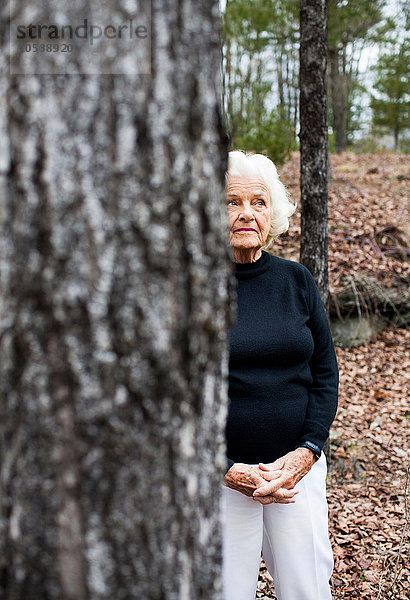 Porträt einer älteren Frau im Wald  Hände umklammert