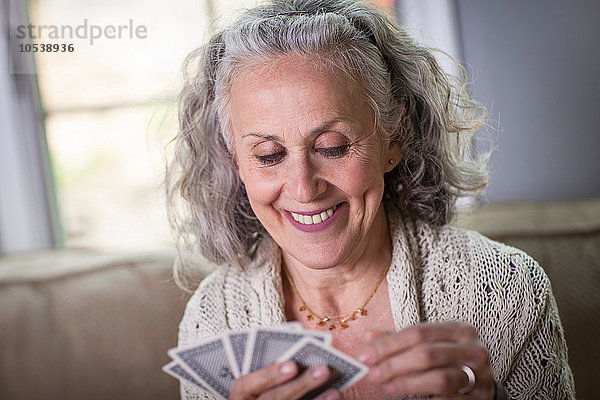 Seniorin beim Kartenspiel zu Hause