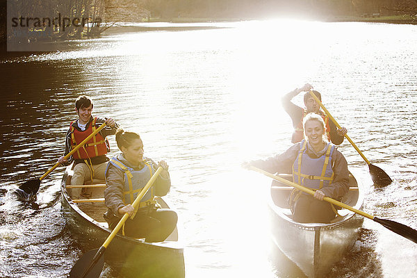 Freunde rudern Kanus auf dem stillen See