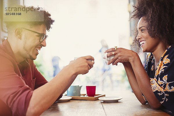 Paar trinkt Kaffee von Angesicht zu Angesicht im Cafe