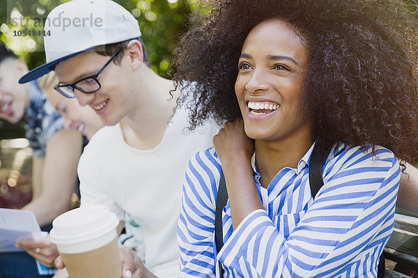 Lächelnde Frau mit Afro-Kaffee trinken mit Freunden im Freien