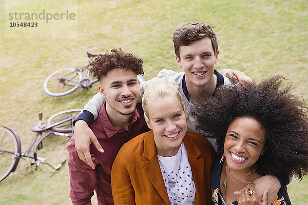 Portrait lächelnde Freunde beim Umarmen im Park