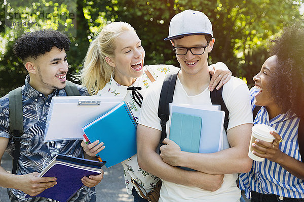 Enthusiastische Studenten scherzen mit Freunden draußen