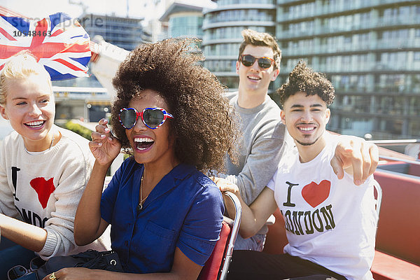 Portrait begeisterte Freunde mit britischer Flagge im Doppeldeckerbus