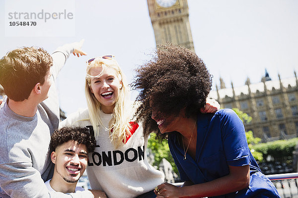 Begeisterte Freunde  die lachen und auf den Big Ben-Uhrturm zeigen  London  Vereinigtes Königreich