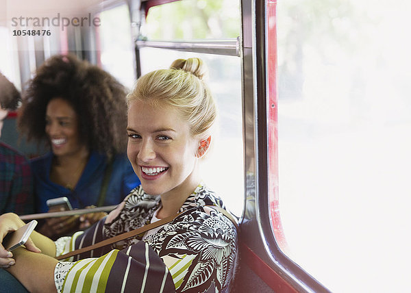 Portrait lächelnde blonde Frau beim Busfahren