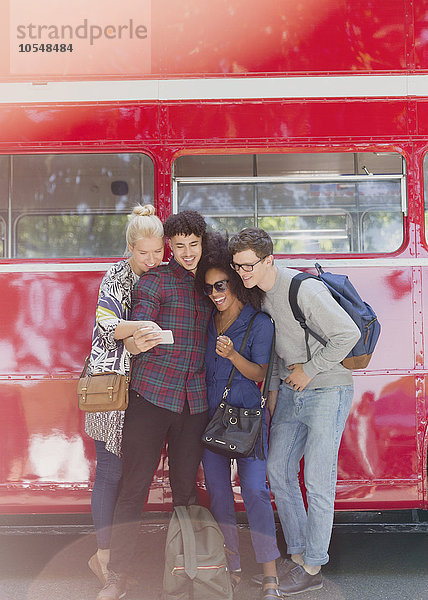 Freunde mit Selfie neben dem Doppeldecker-Bus