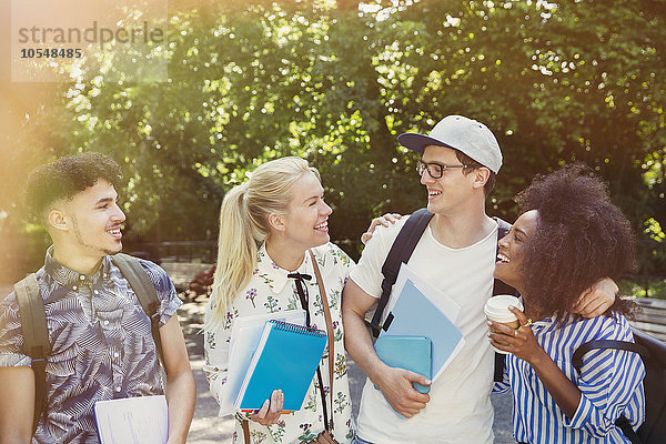 Studenten mit Büchern und Kaffee im Park