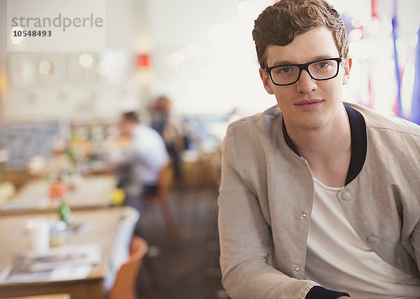 Porträt selbstbewusster Mann mit Brille im Café