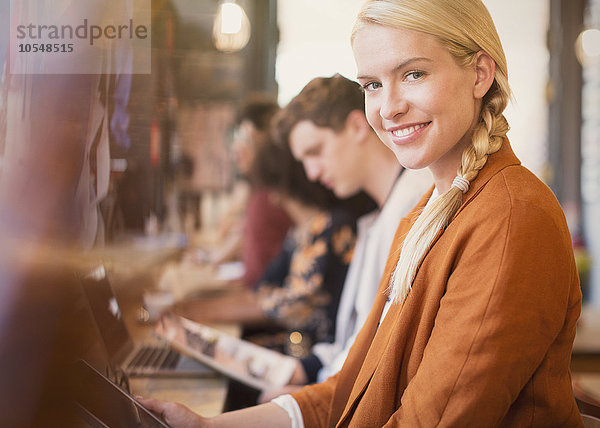 Portrait lächelnde blonde Frau mit digitalem Tablett im Cafe