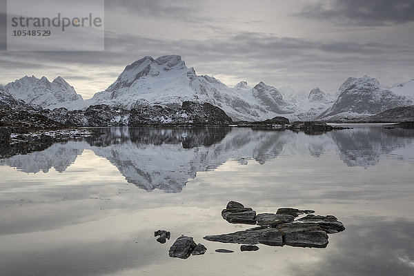 Spiegelung der schneebedeckten Bergkette im ruhigen See  Norwegen
