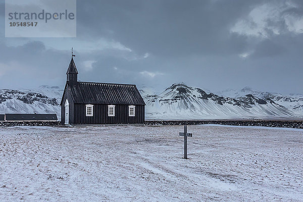 Kirche und Friedhof in verschneiter Berglandschaft  Budir  Snaefellsnes  Island