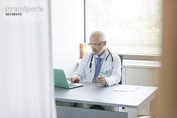 Arzt arbeitet am Laptop in der Arztpraxis