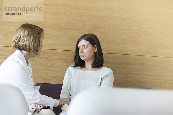 Arzt tröstet ernsthaften Patienten in der Kliniklobby