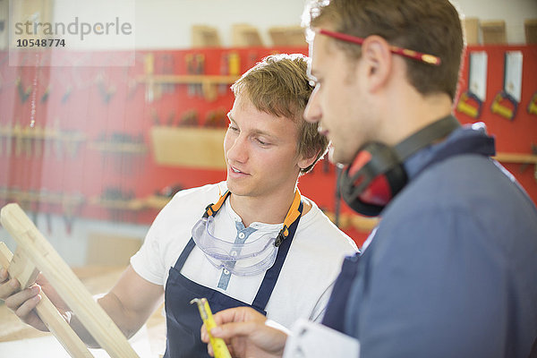 Schreiner untersuchen Holz in der Werkstatt