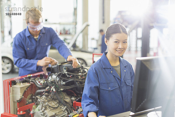 Portrait lächelnde Mechanikerin am Computer in der Autowerkstatt